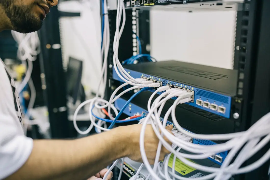 An engineer connecting network cables inside a server rack